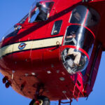 A heavy-lift Sikorsky S-64 Skycrane Helicopter in downtown Minneapolis bringing HVAC materials to the US Bank Plaza roof.