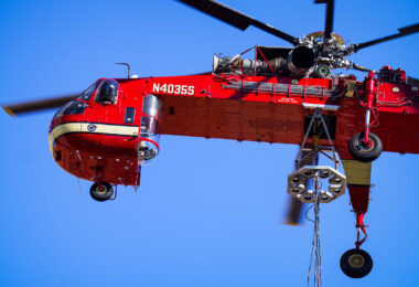 A heavy-lift Sikorsky S-64 Skycrane Helicopter in downtown Minneapolis bringing HVAC materials to the US Bank Plaza roof.