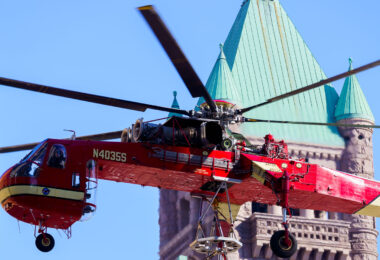 A heavy-lift Sikorsky S-64 Skycrane Helicopter in downtown Minneapolis bringing HVAC materials to the US Bank Plaza roof.