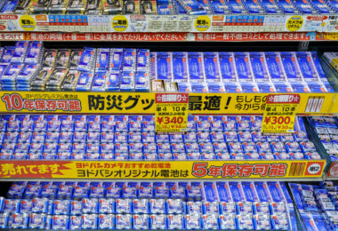 A densely stocked battery display inside Yodobashi Camera’s Shinjuku complex in March 2023. Yodobashi’s in-house battery line is prominently featured, with signage advertising long shelf-life options—10-year storage for premium models and 5-year storage for standard packs. Clear price labeling, bulk multi-pack options, and emergency-preparedness messaging reflect the store’s emphasis on reliability and daily-use electronics.

Yodobashi Camera Shinjuku is one of Tokyo’s largest electronics hubs, spanning multiple buildings near the west exit of Shinjuku Station. Its battery aisles exemplify the retailer’s merchandising style: bright color-coded labels, multilingual product cues, and high-volume stock arranged for quick comparison by commuters and tourists alike.