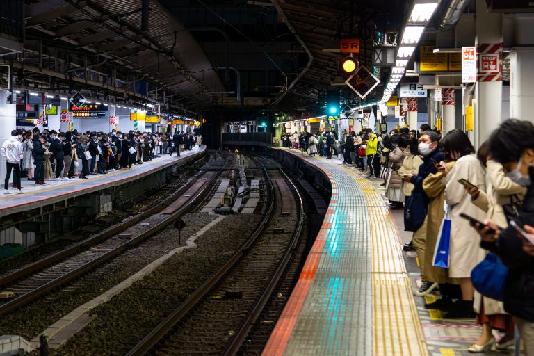 Evening Rush on the Platform, Shinjuku Station, Tokyo 3 Passengers wait on both platforms at a Japanese railway station during evening hours.