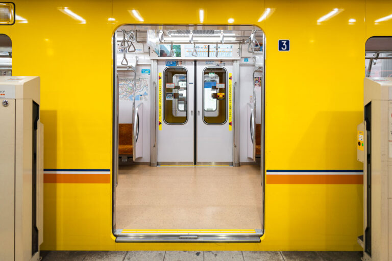 Tokyo Metro Marunouchi Line Series 2000 Train Interior, Japan 2 Tokyo’s Marunouchi Line is one of Japan’s oldest and busiest subway routes, linking major commercial and governmental districts through a network that dates back to 1954. This view shows the Series 2000 rolling stock, a modernized fleet introduced by Tokyo Metro beginning in 2019 to replace aging Series 02 cars.The trains feature energy-efficient LED lighting, regenerative braking, and improved accessibility through wider doorways and level boarding. Their bright yellow exterior, trimmed with red and blue stripes, preserves the line’s traditional color while emphasizing the sleek, minimalist design typical of contemporary Japanese transit engineering.Inside, the cabin layout prioritizes capacity and passenger flow, with longitudinal bench seating covered in patterned orange upholstery and overhead digital route displays in both Japanese and English. The Marunouchi Line operates on a 1,500 V DC overhead catenary and runs entirely underground except for a brief surface section near Nakano-Sakaue, connecting Ikebukuro to Ogikubo over a 24.2-kilometer route that handles hundreds of thousands of passengers daily.