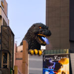 The Godzilla Head overlooking Kabukichō is one of Shinjuku’s most recognizable modern landmarks. Installed in 2015 to mark the opening of the Toho Cinemas Shinjuku complex—the studio responsible for the original 1954 Godzilla film—the sculpture rises above the building’s eighth floor, facing the main entertainment district.

The installation recreates Godzilla’s appearance from the 1990s Heisei-era films, and several times a day it emits sound, smoke, and light effects that mimic the creature’s trademark atomic breath. Positioned above the Kabukichō streetscape, the figure is intended as both a tribute to Japan’s most famous movie monster and a visual anchor for this entertainment-heavy part of Shinjuku.