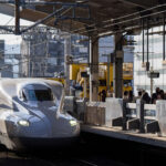 An N700A-series Shinkansen arrives at Kyoto Station, one of the busiest hubs on the Tōkaidō and San’yō Shinkansen network. Introduced by JR Central as an upgraded variant of the earlier N700 design, the N700A incorporated improved braking, enhanced bogies, and automatic train control refinements, supporting smoother high-speed operation along Japan’s primary intercity corridor.

Kyoto Station has served Shinkansen services since 1964, when the original Tōkaidō Line opened for the Tokyo–Osaka route ahead of the Tokyo Olympics. Today it remains a major interchange for regional and long-distance rail, handling millions of passengers annually traveling between Kansai, Tokyo, and the Chūgoku region.