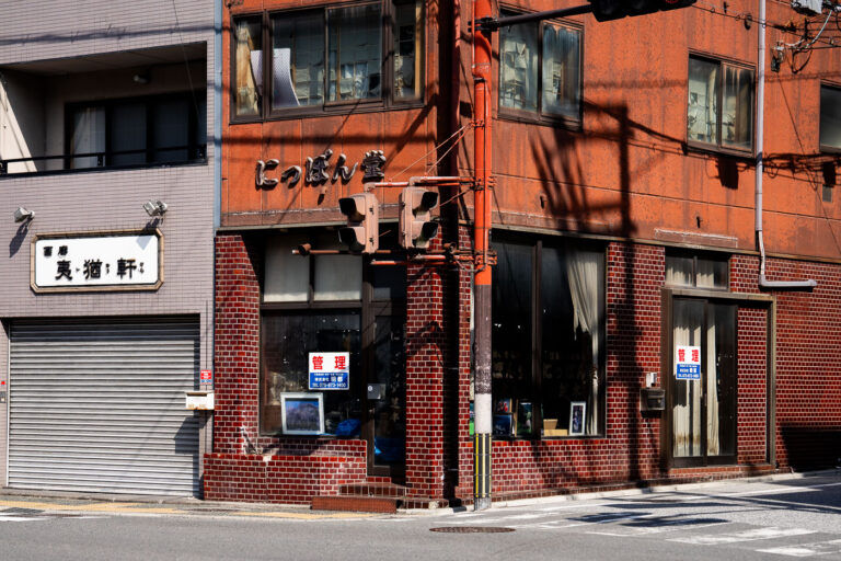 Nippondo Building and Street Corner, Kyoto 4 The Nippondo Building, a mid-20th century commercial structure with a weathered orange facade, stands at a street corner in Kyoto, Japan, featuring traditional signage and traffic signals.