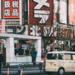Outside Yodobashi Camera’s flagship complex in Shinjuku, one of Tokyo’s largest and most recognizable electronics retail districts. The chain has been a central part of Shinjuku’s commercial landscape since the 1970s, growing alongside the area’s transformation into a major hub for cameras, audio equipment, computers, and home electronics.

By the early 2000s the Shinjuku stores had expanded into a multi-building network around the west side of the station, offering tax-free shopping, dedicated gaming and computer floors, and an extensive camera department that continues to attract both professionals and tourists. Shinjuku’s dense signage, narrow traffic lanes, and steady crowds reflect the district’s role as one of Japan’s busiest shopping zones, with Yodobashi Camera remaining a key anchor of the neighborhood’s retail identity through 2023.