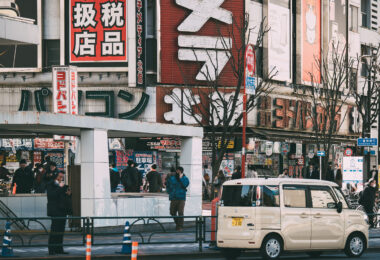 Outside Yodobashi Camera’s flagship complex in Shinjuku, one of Tokyo’s largest and most recognizable electronics retail districts. The chain has been a central part of Shinjuku’s commercial landscape since the 1970s, growing alongside the area’s transformation into a major hub for cameras, audio equipment, computers, and home electronics.

By the early 2000s the Shinjuku stores had expanded into a multi-building network around the west side of the station, offering tax-free shopping, dedicated gaming and computer floors, and an extensive camera department that continues to attract both professionals and tourists. Shinjuku’s dense signage, narrow traffic lanes, and steady crowds reflect the district’s role as one of Japan’s busiest shopping zones, with Yodobashi Camera remaining a key anchor of the neighborhood’s retail identity through 2023.