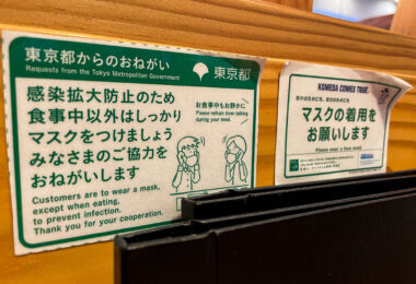 Printed notices from the Tokyo Metropolitan Government remind customers to wear masks except while eating, part of Japan’s ongoing public health etiquette during the pandemic era. The bilingual signs, featuring polite phrasing and simple illustrations, reflect Japan’s emphasis on community responsibility and quiet cooperation.