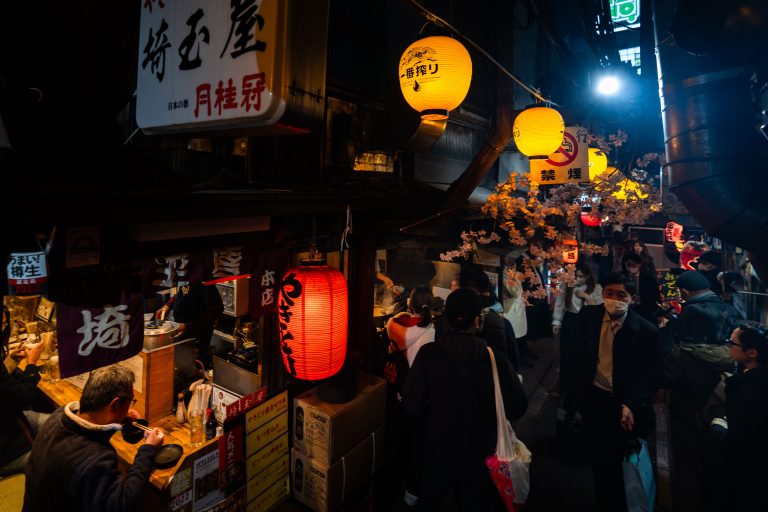 Yakitori Alley, Omoide Yokocho, Shinjuku 3 Nighttime street festival in Japan with illuminated lanterns, vendor stalls, and crowds of pedestrians.