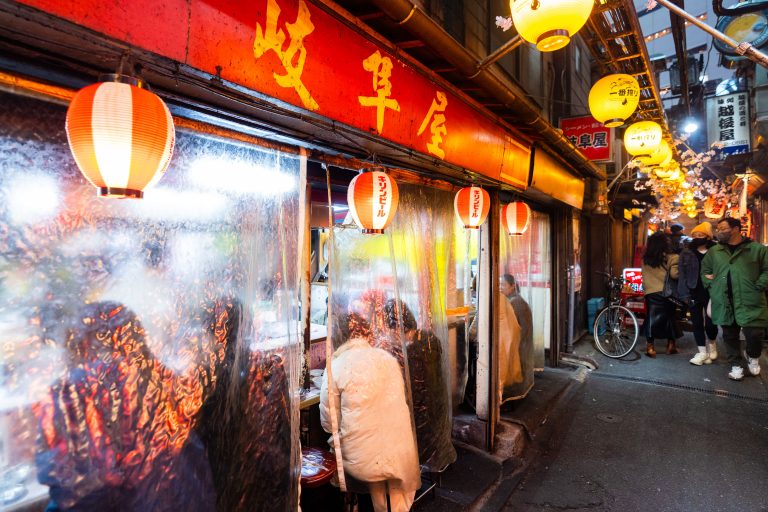 Yakitori Stalls at Omoide Yokocho, Shinjuku 2 Illuminated storefront with red signage and paper lanterns in a Japanese street market at night.
