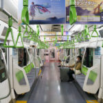 An interior view of a JR East E235 series train on the Yamanote Line, photographed in March 2023. Introduced beginning in 2015, the E235 fleet modernized one of Tokyo’s busiest rail corridors with full-width LCD displays, energy-efficient systems, and redesigned seating meant to improve passenger flow during peak congestion.

The Yamanote Line has operated as Tokyo’s central loop since 1925, linking major districts such as Shinjuku, Shibuya, Ueno, and Tokyo Station. Its frequent headways—often under three minutes—make it a fundamental component of the city’s rail network.

In this off-peak moment, the largely empty car highlights features typical of contemporary JR East design: bright color-coded grab handles, platform-screen door alignment, and extensive in-car advertising screens catering to both commuters and visitors navigating the metropolitan loop.