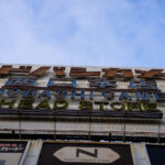 The iconic neon sign of Yodobashi Camera’s head store in Shinjuku is seen from street level, with its mix of Japanese and English lettering. The large retro-style signage, lined with anti-bird spikes, reflects the store’s long-standing presence as one of Tokyo’s biggest electronics retailers. Yodobashi Camera’s Shinjuku West Exit location serves as the flagship branch, anchoring the city’s vast camera and tech shopping district.