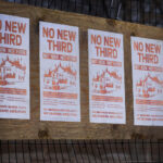Flyers reading "WE REMEMBER GEORGE FLOYD. WE DEMAND ABOLITION." hang on the former burned Minneapolis police 3rd precinct after a week of what is being called "community conversations". City is asking for input on if a precinct should be rebuilt at same location or down the road.