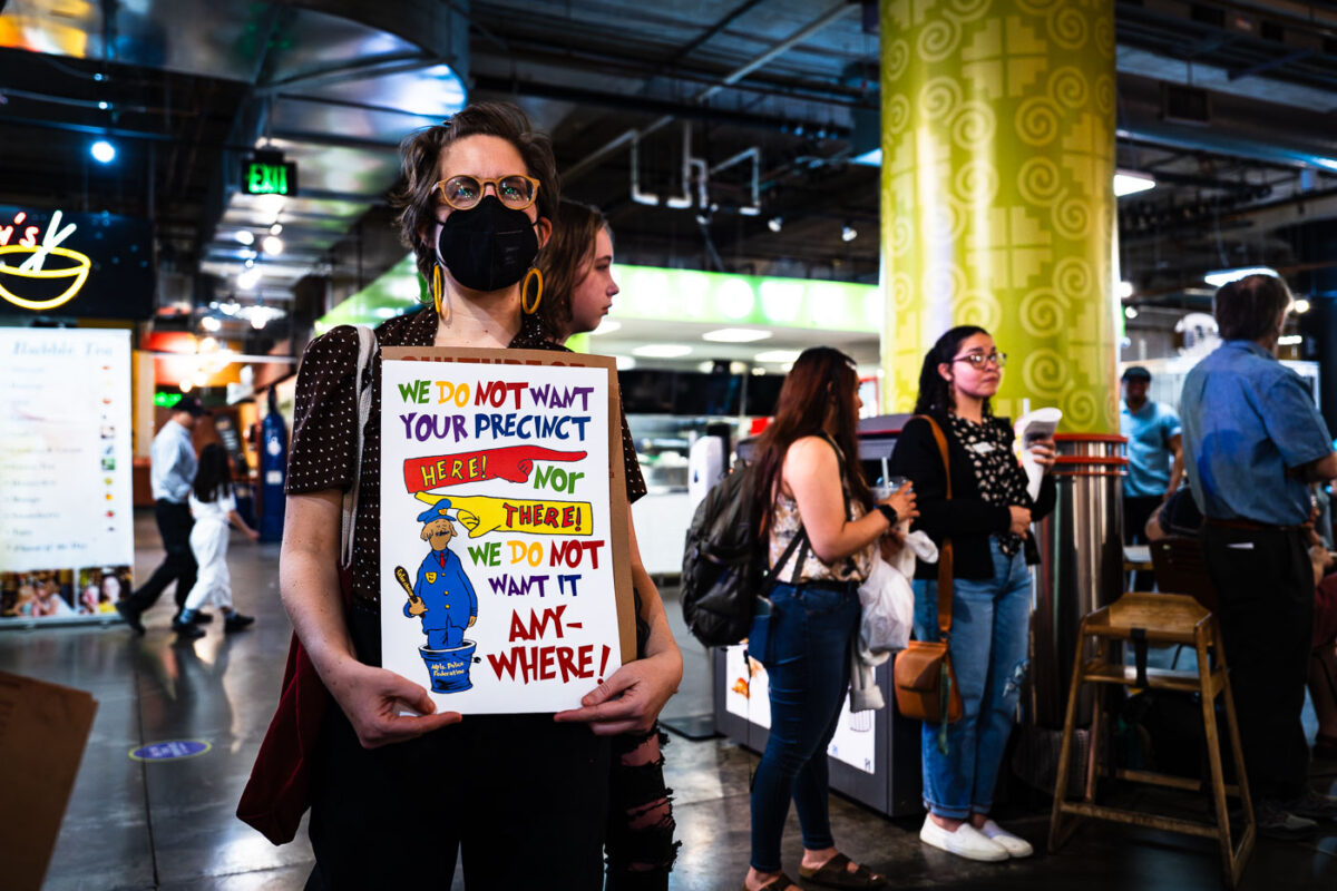 Protest sign at new police station meeting