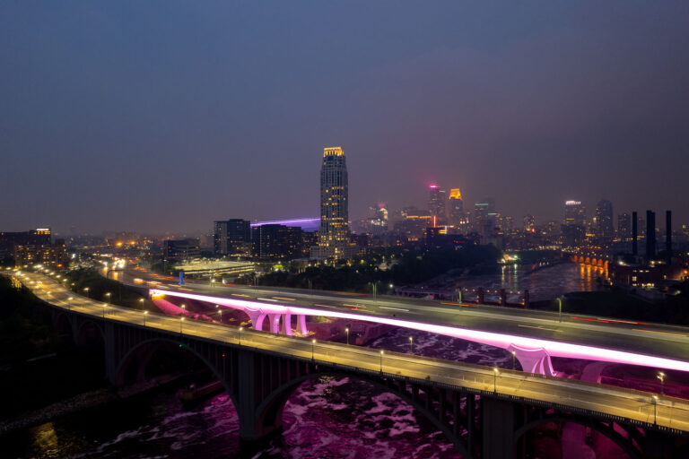 Minneapolis I-35W Bridge in Wildfire Smoke 3 The I-35W Bridge and the 10th Avenue Bridge cross the Mississippi River in Minneapolis, Minnesota, under a sky obscured by smoke from Canadian wildfires. This atmospheric condition, which led to air quality advisories, significantly reduced visibility across the city. The I-35W Bridge serves as a major north-south transportation route, while the 10th Avenue Bridge, with its distinctive arches, is a notable element of the city's infrastructure.