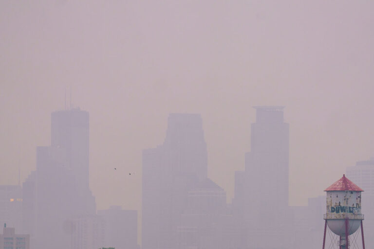 Minneapolis Skyline Obscured by Wildfire Smoke 3 Wildfire smoke from Canada drifts into Minneapolis, significantly reducing visibility of the downtown skyline. The smoke, a result of widespread wildfires, impacted air quality across the region. The image also shows a water tower, a common feature in urban environments providing essential water storage and pressure for municipal systems.