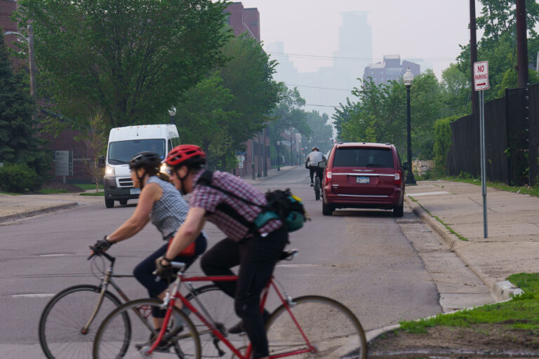 Bikers on Midtown Greenway Amidst Wildfire Smoke, Minneapolis 1 Bicyclists navigate the Midtown Greenway in Minneapolis under a sky obscured by smoke from Canadian wildfires. The Midtown Greenway is a 5.7-mile-long trail built on a former railroad corridor, serving as a vital piece of the city's active transportation network. This trail provides a safe and accessible route for cyclists and pedestrians, connecting various neighborhoods and parks across the city. The heavy haze, a result of widespread wildfires, significantly impacted air quality across the Midwest during the summer of 2023, highlighting the environmental challenges faced by urban areas.