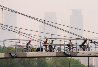 Bikers cross the Martin Olav Sabo Bridge in South Minneapolis as air quality alerts are issued due to drifting south Canadian wildfire smoke.