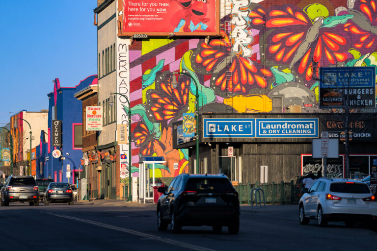 Lake Street, Minneapolis: Colorful Mural and Businesses 3 Lake Street in South Minneapolis is a vibrant commercial corridor known for its diverse businesses and public art. This mural, featuring colorful butterflies and abstract patterns, adorns the side of a building, adding visual interest to the urban environment. The street is a hub for local commerce, with establishments like Super Mercado Morelia and Logan's Burgers & Chicken serving the community. The area has a history of resilience, particularly following the 2020 Minneapolis Uprising, where community art and local businesses played a significant role in the neighborhood's recovery and identity.