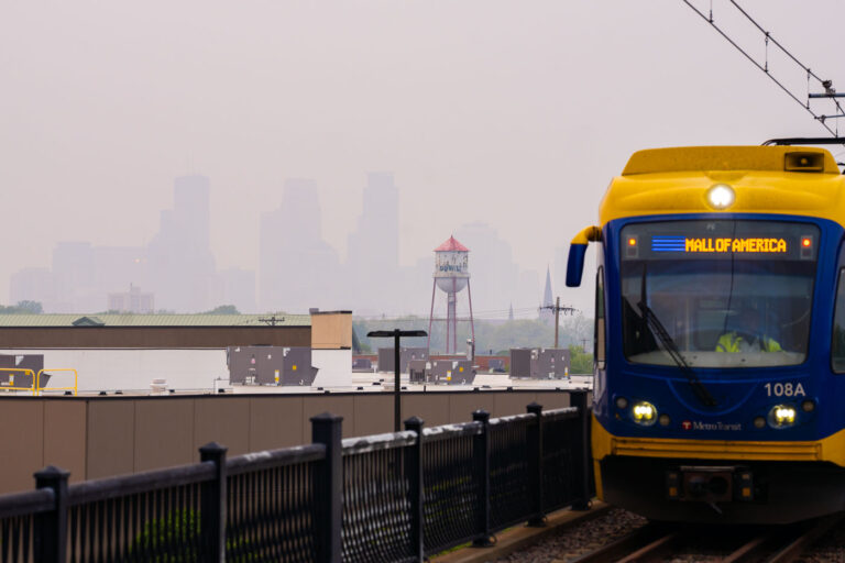 Light rail train and a barely visible Downtown Minneapolis 1 Downtown Minneapolis barely visible as a Metro Transit Light Rail train cross the bridge.