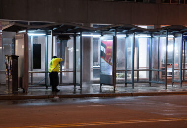 Minneapolis DID worker pressure cleaning a bus stop in downtown Minneapolis.
