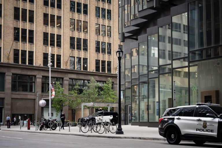 Minneapolis Police Squad Cars on Nicollet Mall near IDS Center 3 Minneapolis Police squad cars are parked on Nicollet Mall, a prominent pedestrian thoroughfare in downtown Minneapolis. Nicollet Mall, designed by architect Lawrence Halprin, was established in the 1960s as a pedestrian zone to revitalize the city's core and has since become a central hub for commerce, culture, and public life. The presence of police vehicles on the mall, particularly in the context of the Minneapolis Uprising following the murder of George Floyd in 2020, signifies the complex role of law enforcement in managing public spaces during times of civil unrest and heightened community tension. The IDS Center, a landmark skyscraper visible in the background, further anchors the location within Minneapolis's central business district.