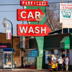 A street vendor selling plush toys on Lake Street. Park & Lake Car Wash in the background.