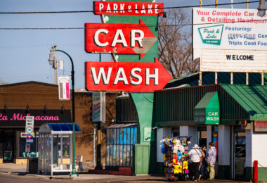 A street vendor selling plush toys on Lake Street. Park & Lake Car Wash in the background.