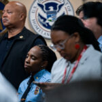 A Minneapolis police officer watches as the Department of Justice announces their findings of an investigation into the Minneapolis police department.