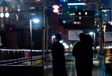 A group looks at the newly installed fence at the end of the Stone Arch Bridge.