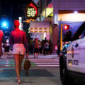 People walking across the street near the Gay 90s Nightclub on Hennepin Avenue in Downtown Minneapolis in July 2023.