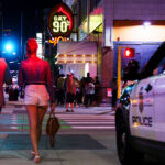 People walking across the street near the Gay 90s Nightclub on Hennepin Avenue in Downtown Minneapolis in July 2023.