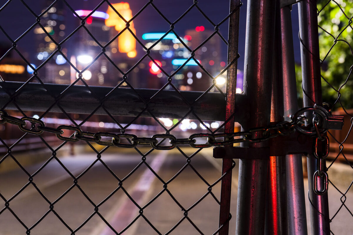 Looking through locked fence of the Stone Arch Bridge. The bridge was closed due to reports of late night crime.