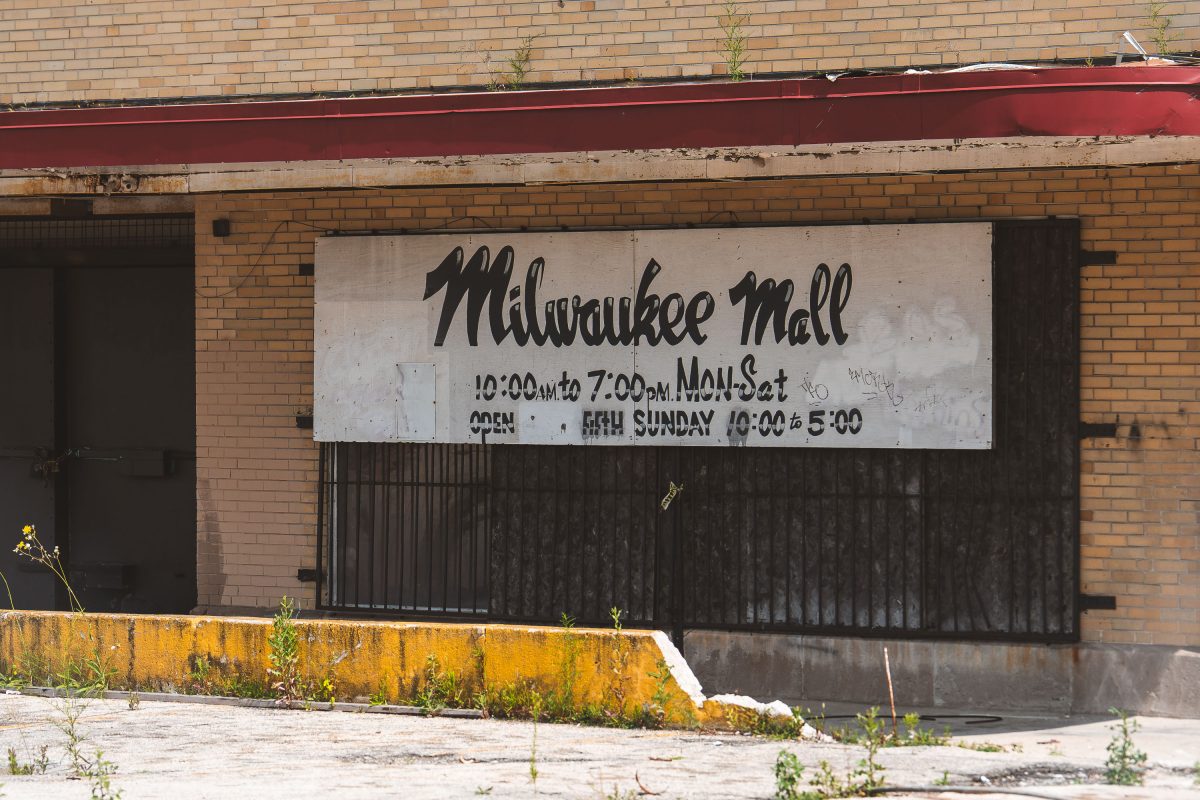 Abandoned Milwaukee Mall storefront with faded signage on a brick building in Milwaukee, Wisconsin.