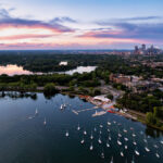 Sailboats on Bde Maka Ska in Minneapolis during sunset. Lake of the Isles seen in the distance.
