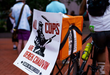 A protester at a rally outside the Hennepin County Courthouse with a sign that reads “All Crops Are Derek Chauvin”. Those at the rally are asking for Hennepin Attorney Mary Moriarty to charge the Minnesota State Trooper Ryan Londregan in the killing of Ricky Cobb II. Cobb was killed on July 31 after being shot during a traffic stop.