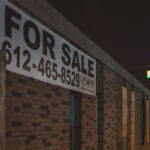 A Upload Real Estate Group For Sale sign on a building in downtown Minneapolis.