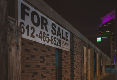 A Upload Real Estate Group For Sale sign on a building in downtown Minneapolis.