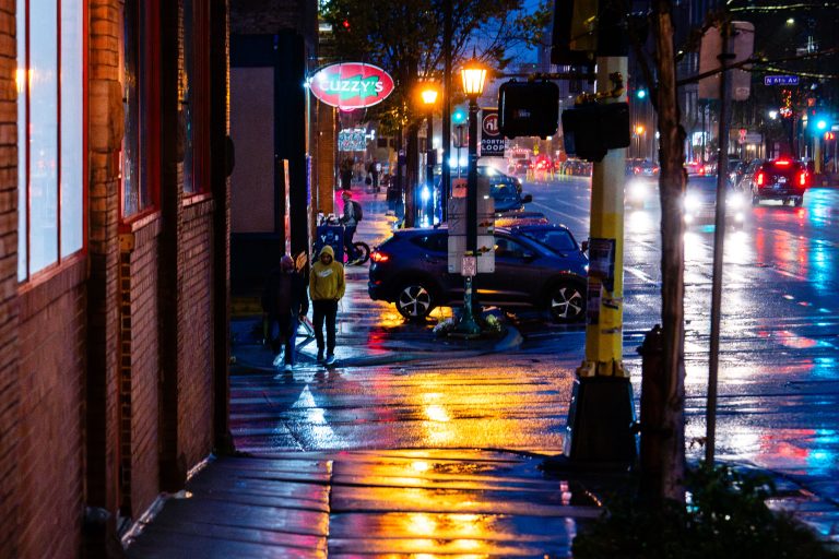 Cuzzy's Bar on Washington Avenue, North Loop 2 Wet downtown Minneapolis street at night with neon Cuzzy's bar sign and parked vehicles.