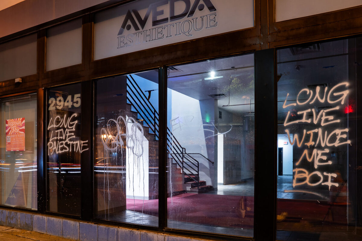 Graffiti reading "LONG LIVE PALESTINE" and "LONG LIVE WINCE ME BOI" spray-painted on the windows of the former Juut salon at 2945 Hennepin Avenue in Uptown Minneapolis.