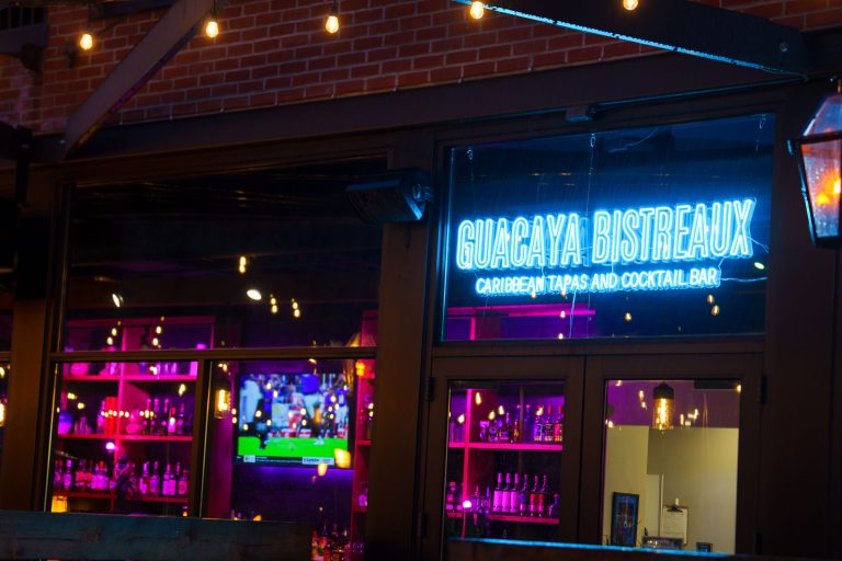 Guacaya Bistreaux Caribbean Tapas Bar, Washington Avenue 3 Guacaya Bistreaux Caribbean tapas and cocktail bar storefront displays a neon sign at night in Minneapolis.