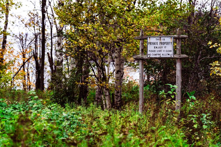 Private Property Hiking Sign, Beaver Bay, Minnesota 1 Weathered private property sign on wooden posts in overgrown woodland near Beaver Bay, Minnesota.