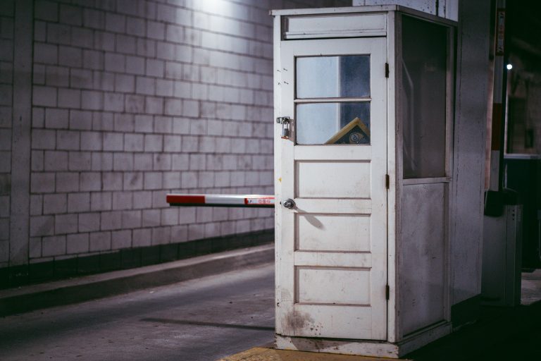 Attendant's Booth, Parking Ramp in Downtown Minneapolis 1 White metal door with window in brick parking garage corridor, Minneapolis.