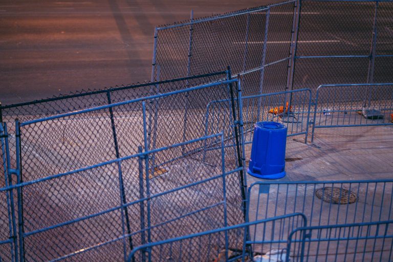 Barricades and Trash Bin Near US Bank Stadium, Minneapolis 3 Blue chain-link fencing and barriers surround US Bank Stadium in downtown Minneapolis at dusk.