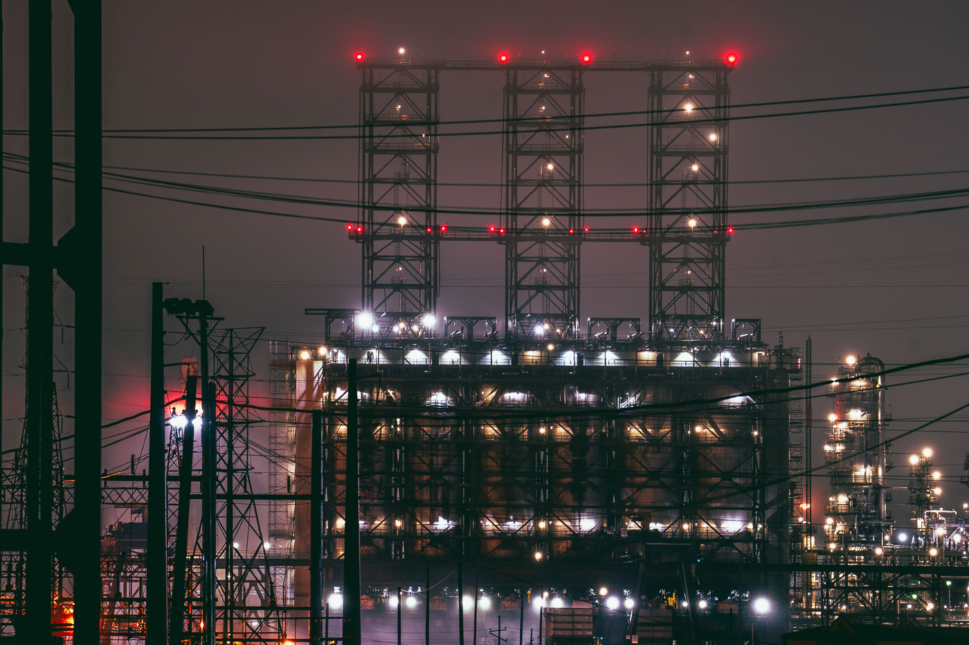 The BP Whiting Refinery in Indiana, the Midwest's largest oil facility, is illuminated at night with complex industrial structures and towers.