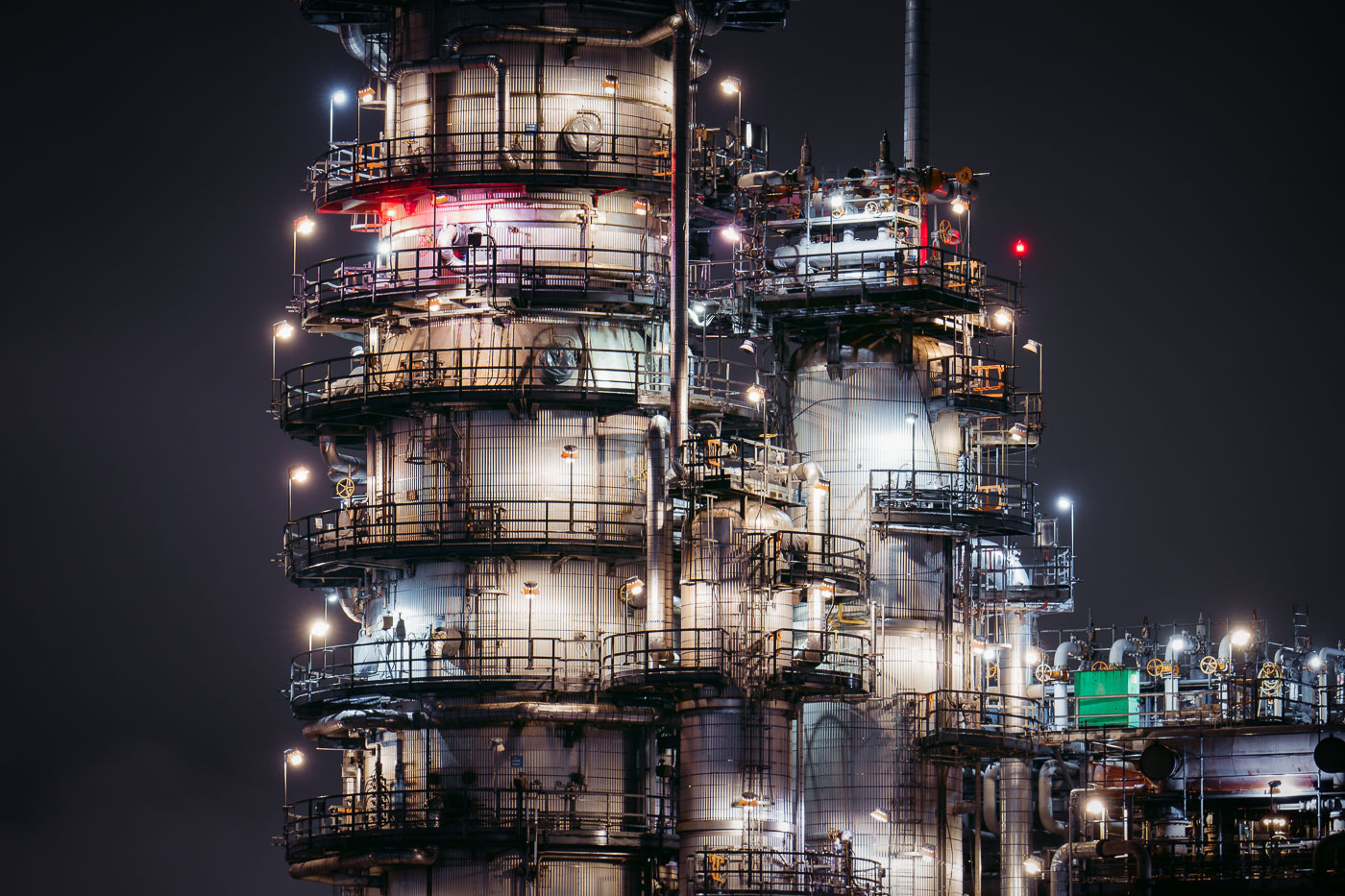 The BP Whiting Refinery in Whiting, Indiana, the Midwest's largest oil processing facility, is illuminated at night, showcasing its complex distillation towers and piping.