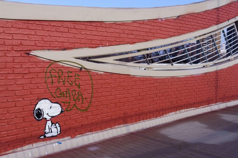 Snoopy Mural with "Free Gaza" Speech Bubble, Loring Greenway 2 Snoopy character graffiti with "Free Gaza" text on red brick wall along Loring Greenway in Minneapolis.