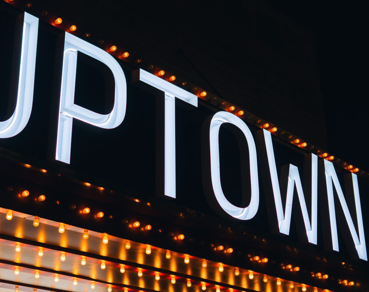 Uptown Theater marquee in Minneapolis lit against a dark night sky.