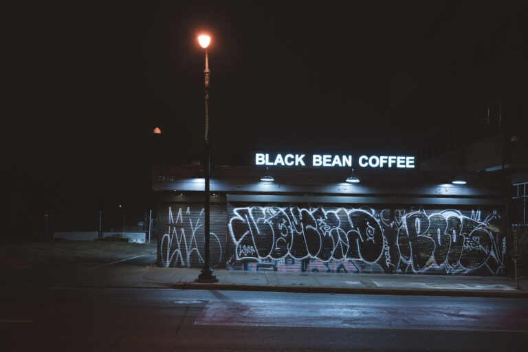 Black Bean Coffee at night 4 Black Bean Coffee on Chicago Avenue in Minneapolis with graffiti on the front shutters. January 2024.