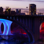 The 10th Avenue and I-35W bridges lit up at sunset near downtown Minneapolis. March 2024.